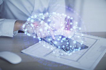 Double exposure of man's hand holding and using a digital device and brain hologram drawing. Data...