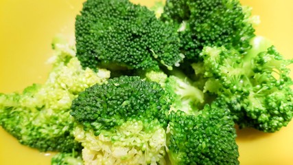 Fresh broccoli on a yellow background in closeup