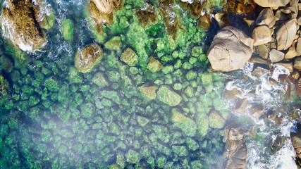 Panoramic overhead downward aerial view of beautiful tropical beach with rocks