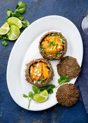 Sea Urchins caviar in shell with onion and cilantro. Top view. On trendy classic blue background