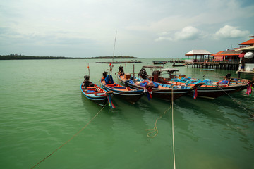 Fototapeta na wymiar Longtail boat with coastal fishing village at koh rat suratthani Thailand.