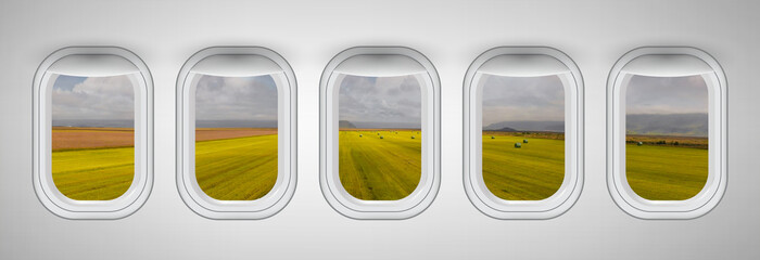Hay bales and green meadows as seen through airplane windows. Holiday and travel concept