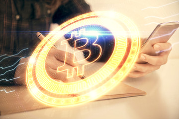 Double exposure of blockchain business sketch hologram and woman holding and using a mobile device.