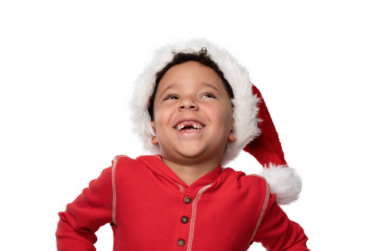 portrait of a boy in Santa hat with a big smile and head back, missing his two front teeth