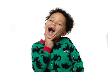 portrait of a boy in Christmas pyjamas making a faces showing off his missing two front teeth