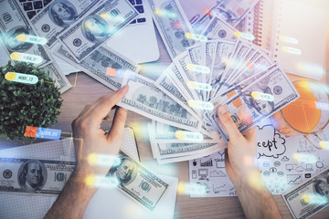 Multi exposure of technology drawing hologram and us dollars bills and man hands. Data concept