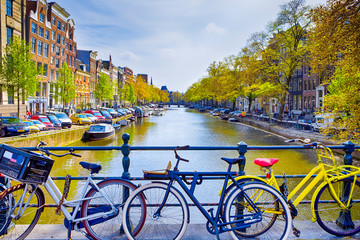 Fototapeta premium Traveling In the Netherlands. City of Amsterdam. Traditional Dutch Bicycles In Front of Amsterdam Canal.