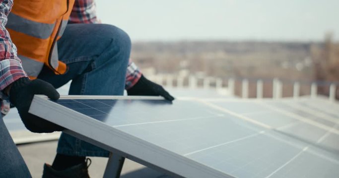 Technicians installing solar panels on metal stand
