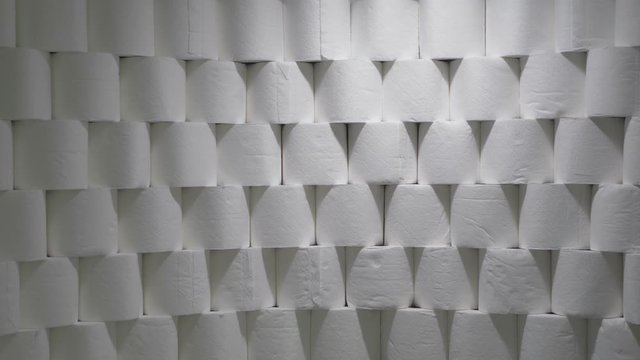 Toilet Paper Rolls Stacked In Rows. Light Moves To The Right And Back To The Left