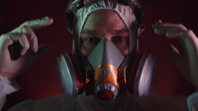 Man in protective costume suit, gas protect medical antibacterial antiviral spray paint mask. Doctor health worker in respirator. Concept health virus coronavirus epidemic. Radiation Nuclear war.