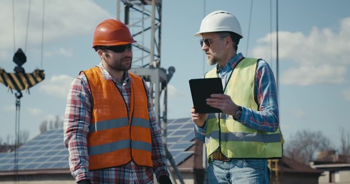 Engineer and technician discussing using tablet
