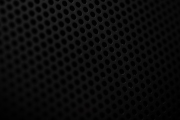Black metal texture with round holes. Industrial background.