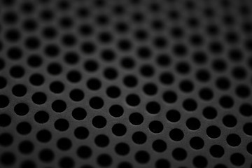 Black metal texture with round holes. Industrial background.