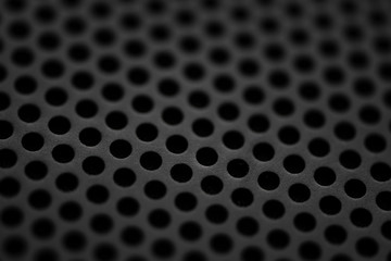 Black metal texture with round holes. Industrial background.
