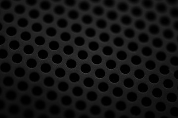 Black metal texture with round holes. Industrial background.