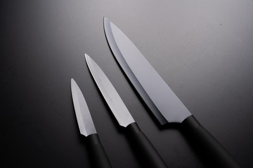 Black chef knife isolated on black background.