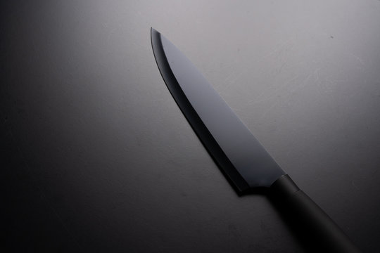 Black chef knife isolated on black background.