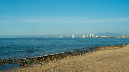 Bright Blue Ocean Beach With Buildings in the Background In Puerto Vallarta Mexico