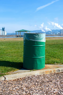 Green Garbage Can Along A Walking Path And Green Grass