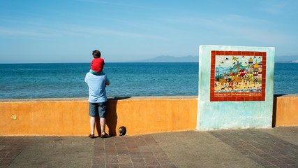Father And Son Looking over the Ocean on the Malecon in Puerto Vallarta Mexico