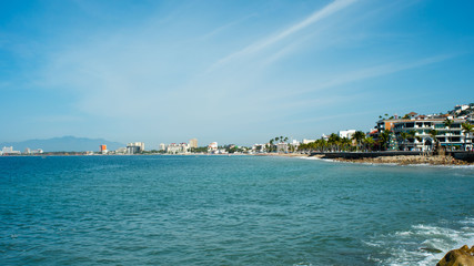 A Bright Blue Beach at Noon with Buildings in the Distance in Puerto Vallarta Mexico