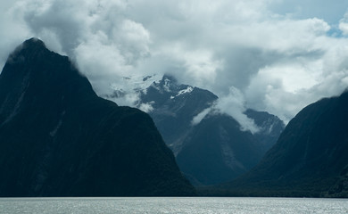 Rolling clouds over mountains and lake at Milford Sound New Zealand