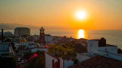 Amazing Orange Sunset Over Blue Ocean on a Rooftop view of Old Town in Puerto Vallarta Mexico