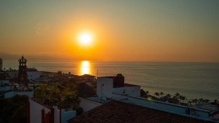 Amazing Orange Sunset Over Blue Ocean on a Rooftop view of Old Town in Puerto Vallarta MexicoAmazing Orange Sunset Over Blue Ocean on a Rooftop view of Old Town in Puerto Vallarta Mexico