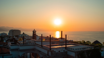 Amazing Orange Sunset Over Blue Ocean on a Rooftop view of Old Town in Puerto Vallarta Mexico