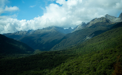 Fototapeta na wymiar Clouds roll over mountains and forest in New Zealand