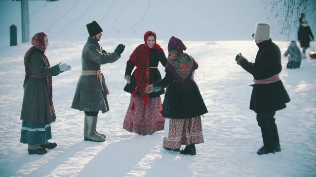 Russian folklore - funny russian people in traditional costumes are having fun on a sunny day
