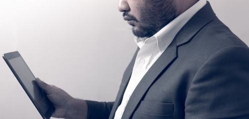 Young bearded business man working with a digital tablet.