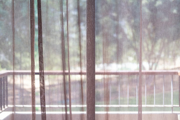 White sheer curtain with garden view.