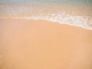 Golden sand on tropical beach near sea. Sea surf close up. Sandy beach and soft wave