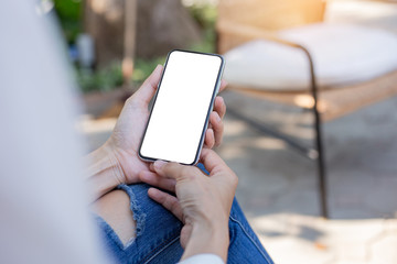 Mockup image blank white screen cell phone.woman hand holding texting using mobile on desk at coffee shop.background empty space for advertise text.people contact marketing business,technology