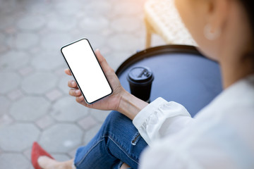 Mockup image blank white screen cell phone.woman hand holding texting using mobile on desk at coffee shop.background empty space for advertise text.people contact marketing business,technology