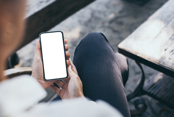 Mockup image blank white screen cell phone.woman hand holding texting using mobile on desk at coffee shop.background empty space for advertise text.people contact marketing business,technology