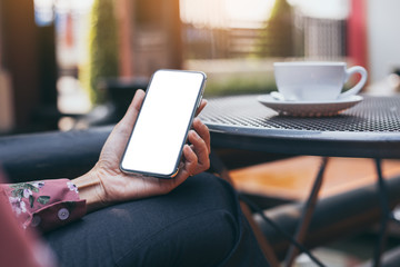 Mockup image blank white screen cell phone.woman hand holding texting using mobile on desk at coffee shop.background empty space for advertise text.people contact marketing business,technology