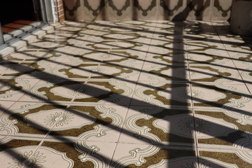 old tiled floor on porch with sunny railings with apartment entrance