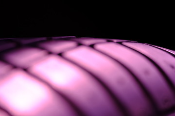 Abstract macro photography – close up tire texture pattern with violet light