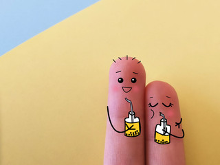 Two fingers are decorated as two friends. They are drinking bubble tea.