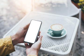 Mockup image blank white screen cell phone.man hand holding texting using mobile on desk at coffee shop.background empty space for advertise text.people contact marketing business,technology