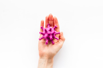 Corona virus Covid-19 - diagnostics concept with strain virus model and hands - on white background top-down