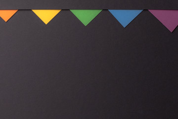 Minimalistic colored triangles on Minimalist Black background, copy space, flat lay top view.