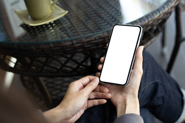 Mockup image blank white screen cell phone.woman hand holding texting using mobile on desk at coffee shop.background empty space for advertise text.people contact marketing business,technology