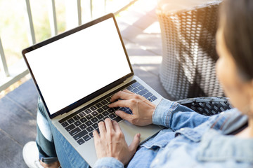 mockup image blank screen computer with white background for advertising text,hand woman using laptop contact business search information on desk at coffee shop.marketing and creative design