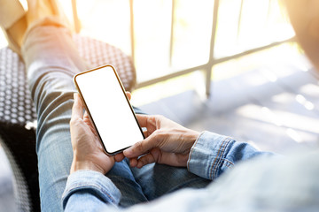 Mockup image blank white screen cell phone.woman hand holding texting using mobile sitting at coffee shop.background empty space for advertise text.people contact marketing business,technology