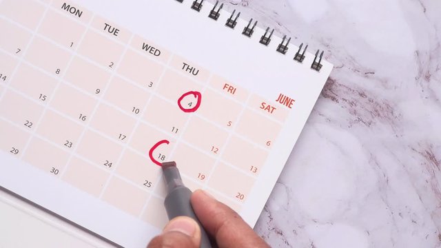 man's hand with pen marking on calendar, deadline concept 