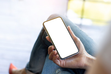 Mockup image blank white screen cell phone.woman hand holding texting using mobile on desk at coffee shop.background empty space for advertise text.people contact marketing business,technology