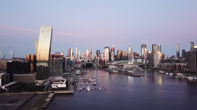 Drone Fly toward Melbourne City over Docklands River Victoria Harbour in sunset